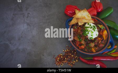 Vegetarische Kind mit hausgemachten Mais Chips auf grauem Schiefer Hintergrund Stockfoto