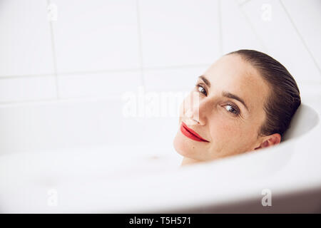 Schöne Frau Entspannung in einem milchbad Stockfoto