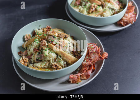 Pilz Risotto mit karamellisierten Birnen und Walnüssen in der Schale, Speck auf Platte Stockfoto