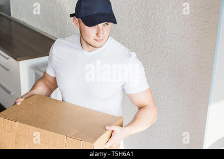 Lieferung starken, muskulösen Mann laden Kartons für den Umzug in eine Wohnung. Professionelle Mitarbeiter von Transport, männliche Lader in Overalls Stockfoto