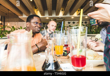 Ansicht von oben. Ein Unternehmen der multikulturellen Gesellschaft junge Menschen in einem Cafe essen Sushi rollen, trinken Getränke Spaß Stockfoto