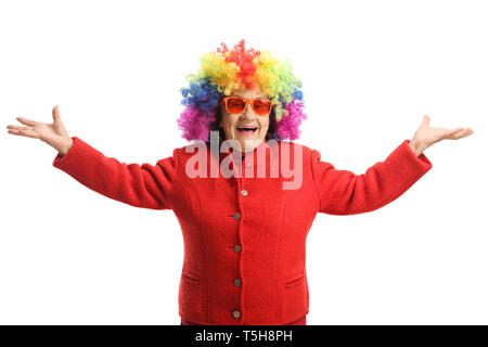 Gerne ältere Dame mit einem roten Mantel und eine bunte Perücke auf weißem Hintergrund Stockfoto