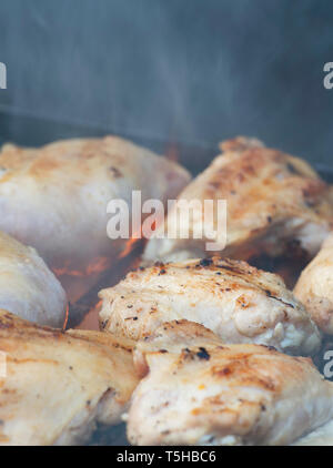 Grillen von Hähnchen Strumpfhose über bbq für eine Party in einem Hinterhof, outdoor Stockfoto