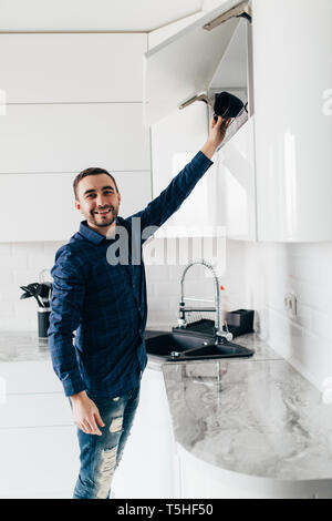 Junger Mann Open Storage in der Küche Stockfoto