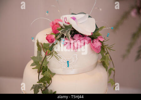Hochzeitstorte, drei abgestufte Hochzeitstorte mit schönen rosa und weißen Blüten Verzieren des Tiers eingerichtet. Stockfoto