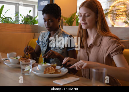 Weibliche Freunde im Restaurant sitzen beim Frühstück Stockfoto