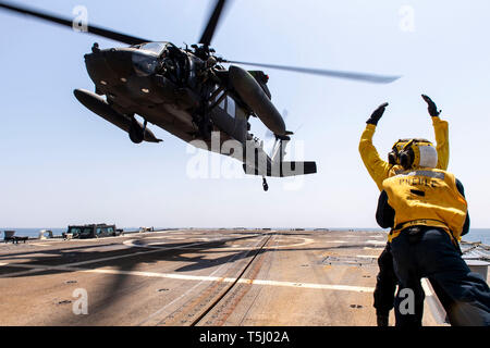 190422-N-UI 104-0308 East China Sea (April 22, 2019) ein US-Marine Sailor zu einem U.S. Army UH-60 Black Hawk Hubschrauber Signale, zugeordnet zu den "Wild Cards" des zweiten Bataillons (Angriff), 2 Aviation Regiment, Angriff Hubschrauber Bataillon (AHB), heben Sie während deck Landung Qualifikationen an Bord der Arleigh-Burke-Klasse geführte Anti-raketen-Zerstörer USS Preble (DDG88). Preble ist in die USA 7 Flotte Bereich für Maßnahmen zur Erhöhung der Sicherheit und Stabilität in der indopazifischen Region bereitgestellt. (U.S. Marine Foto von Mass Communication Specialist 1. Klasse Bryan Niegel/Freigegeben) Stockfoto