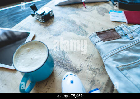 Flugtickets, Reisepass, Kamera, Tablet, jeans, Flugzeug und Karte auf dem Tisch. Die Aussicht von oben. Sammeln für eine Reise oder Reisen Abenteuer zu erfüllen Stockfoto