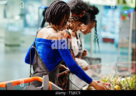 Gruppe der afrikanischen womans mit Warenkorb kaufen exotische Früchte in Lebensmittelgeschäft, Supermarkt. Stockfoto