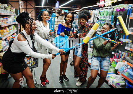 Gruppe von fünf afrikanischen womans mit Staub Mop, WC-Bürste und Schaufel Spaß im Haushalt Reinigung Produkte Abteilung im Supermarkt. Stockfoto