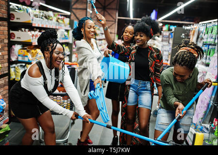 Gruppe von fünf afrikanischen womans mit Staub Mop, WC-Bürste und Schaufel Spaß im Haushalt Reinigung Produkte Abteilung im Supermarkt. Stockfoto