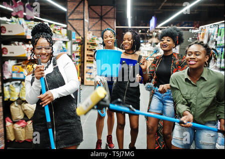 Gruppe von fünf afrikanischen womans mit Staub Mop, WC-Bürste und Schaufel Spaß im Haushalt Reinigung Produkte Abteilung im Supermarkt. Stockfoto