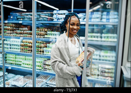 Afrikanische amerikanische Frau in der Nähe von Kühlschrank Regal verkauft Milchprodukte Ei Karton im Supermarkt. Stockfoto