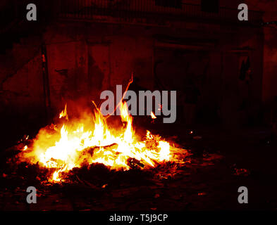 Crazy Straßen von Delhi während Holi Feier. Riesige Freudenfeuer nach rechts in die Straße. Die Leute gehen in der Nähe der Feuer und Hitze Stockfoto