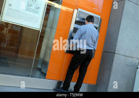 Ansicht von hinten von einem Mann Geld mit einem ATM Geldautomaten Maschine in einer Straße in der Stadt Porto Portugal Europa EU-KATHY DEWITT Stockfoto