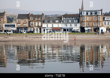 Der Uferpromenade am Helensburgh, Argyll, Schottland mit Reflexionen der Gebäude im Wasser des Flusses Clyde als vom Pier aus gesehen. Stockfoto