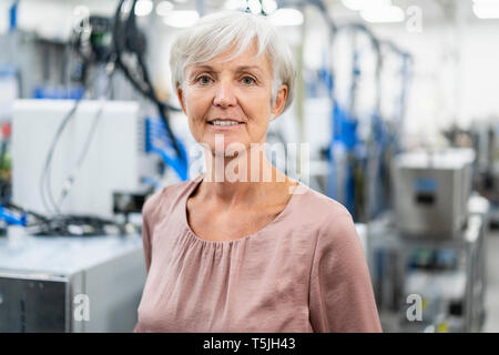 Portrait von zuversichtlich ältere Frau in einer Fabrik Stockfoto