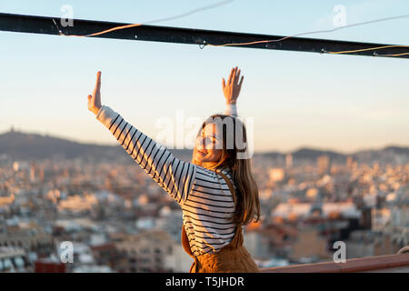 Porträt der glückliche junge Frau, entspannen Sie auf der Dachterrasse bei Sonnenuntergang Stockfoto