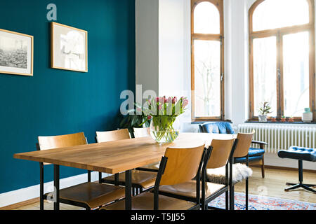 Holztisch und Stühlen mit großer Fensterfront im Wohnzimmer in stilvolles Apartment Stockfoto