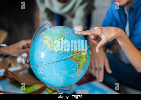 Freunde treffen Urlaub zu planen, zu prüfen Karte und Kugel Stockfoto
