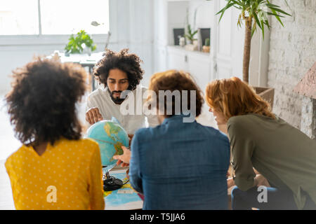 Freunde treffen Urlaub zu planen, zu prüfen Karte und Kugel Stockfoto