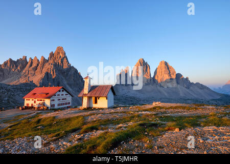 Kapelle und Refugio Antonio Locatelli mit den berühmten Drei Zinnen und Mount Paterno bei Sonnenaufgang, Trentino-Südtirol, Italien Stockfoto