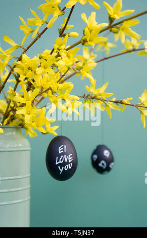 Handbemalte Ostereier hängen von Forsythia Zweige Stockfoto