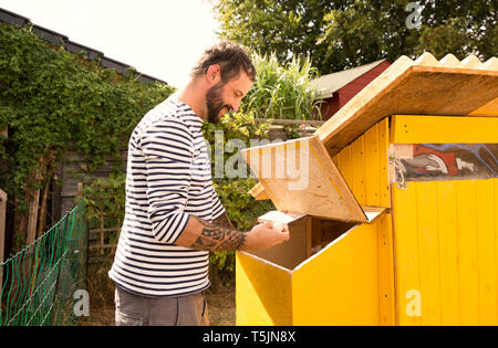 Man Eier sammeln in chickenhouse Stockfoto