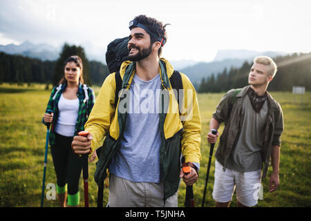 Gruppe der Wanderer zu Fuß auf einem Berg und lächelnd Stockfoto