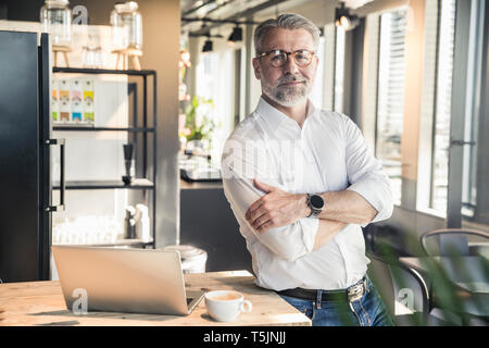 Porträt von zuversichtlich reifer Geschäftsmann im Büro Stockfoto