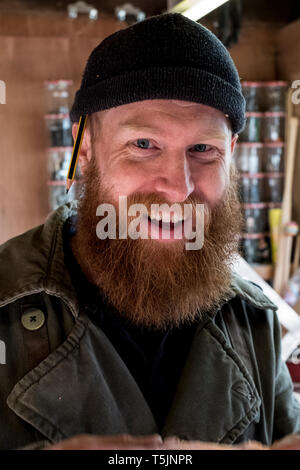 Portrait von lächelnden bärtiger Mann mit hellbraunem Haar, trug schwarze Mütze. Stockfoto