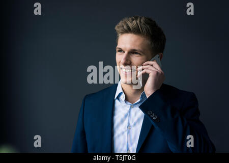 Portrait von lächelnden jungen Geschäftsmann auf Handy Stockfoto
