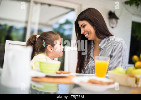 Glückliche Mutter und Tochter Frühstück zu Hause in Stockfoto