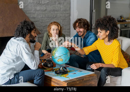 Freunde treffen Urlaub zu planen, zu prüfen Karte und Kugel Stockfoto