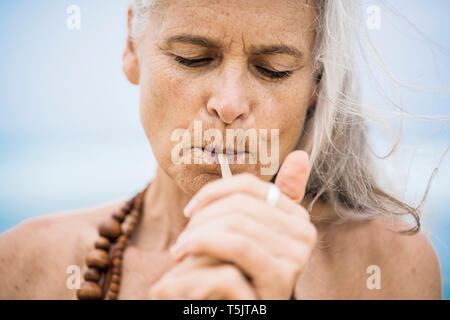 Portrait von Senior hippie Frau Rauchen im Freien Stockfoto