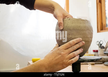 Nahaufnahme von Keramik Künstler in ihrer Werkstatt, Arbeiten auf kleinen Ton Vase. Stockfoto