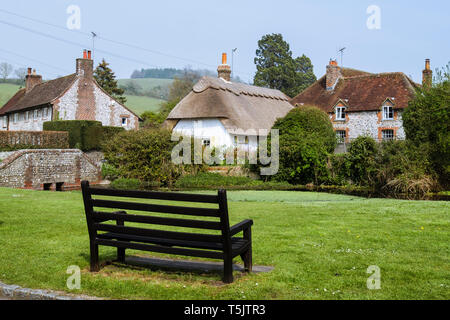 Leeren Bank auf Country Village Green durch Teich in South Downs National Park. Singleton, Chichester, West Sussex, England, Großbritannien, Großbritannien Stockfoto