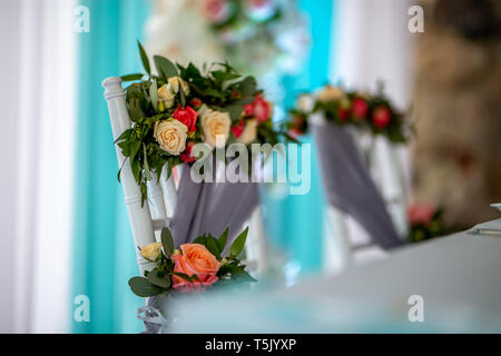 Dekoriert Hochzeit stuhl mit Blumenstrauß aus Rosen. Blumenstrauß aus Rosen am Lehrstuhl für Hochzeit gebunden. Stockfoto