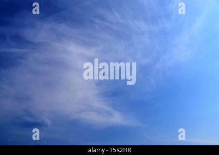 Schöne weiße Zirruswolken hoch in den tiefblauen Himmel Stockfoto