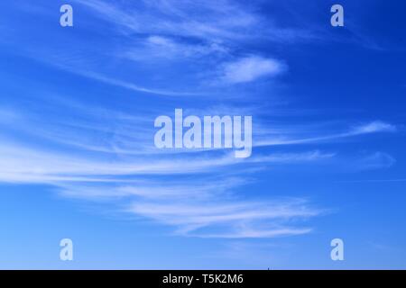 Schöne weiße Zirruswolken hoch in den tiefblauen Himmel Stockfoto