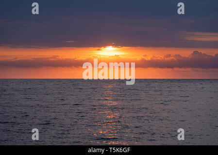 Marine mit einem wunderschönen Sonnenaufgang. Die aufgehende Sonne hinter schönen Wolken versteckt Stockfoto
