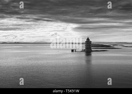 Moody Schwarz-weiß-Foto des Leuchtturms Kjeungskjær auf einer winzigen Insel an der Mündung des Bjugnfjorden in Ørland, Trøndelag, Norwegen. Stockfoto