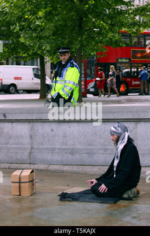 Mann, der betet, Mekka, in Trafalgar Square. Polizei vorwärts Nachrichtenoffiziere (FIT) zu beobachten. London. 16/05/2009 Stockfoto