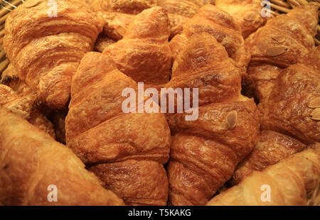 Haufen von frisch gebackenen leckeren almond Croissants Gebäck in der Bäckerei Stockfoto