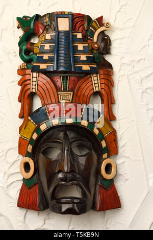 Maya Priester aus geschnitzten Holz bemalte Maske von Chichen Itza Mexiko auf Stuck Wand Stockfoto