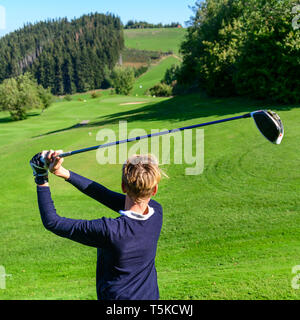 Junior Golfspieler schlagen Kugel Stockfoto