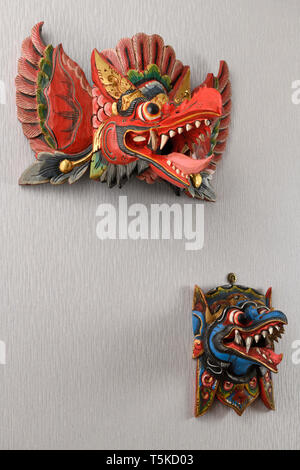 Rot und Blau Balinesischen daemon Barong Tanz Masken von Garuda Indonesia an der Wand aufhängen Stockfoto