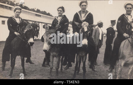 Jahrgang fotografische Postkarte zeigt die britische Royal Navy Sailors Reiten Esel in Port Elizabeth, Südafrika im Jahre 1925. Stockfoto