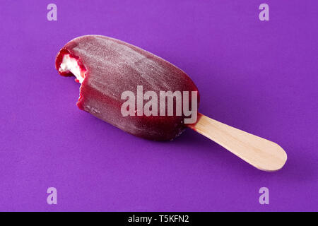 Gebissen Erdbeere popsicle auf Violett Hintergrund. Stockfoto