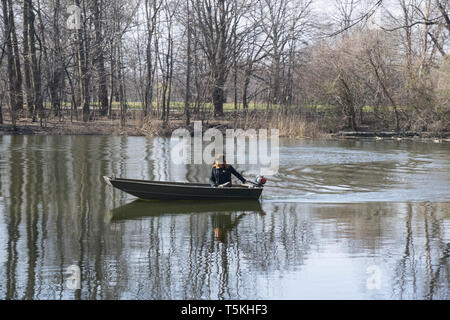 Park Arbeitnehmer in einem motorisierten Boot überprüft die See Umwelt in Prospect Park, Brooklyn, New York. Stockfoto